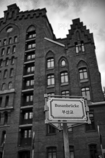 Busan Bridge sign, behind it Peter Tamm International Maritime Museum, warehouses, brick buildings, Hamburger Speicherstadt, Hafencity, black-and-white Free and Hanseatic City of Hamburg, Germany