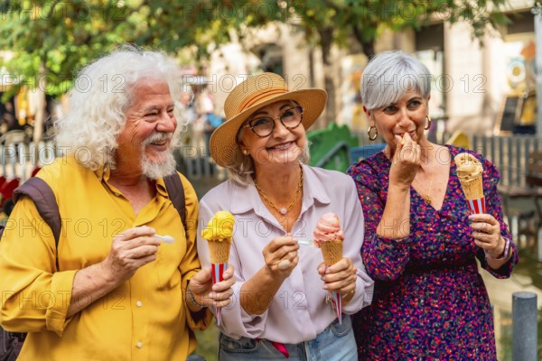 Three happy senior friends, two women and one man, standing outdoors and enjoying colorful ice cream cones on a sunny day, sharing a moment of friendship and summer joy