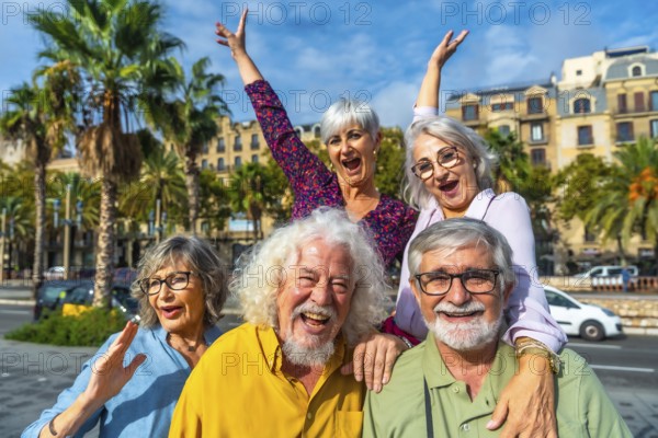 Happy senior friends smiling and raising hands, celebrating friendship and active retirement during a city vacation, conveying joy, togetherness, and a fulfilling lifestyle
