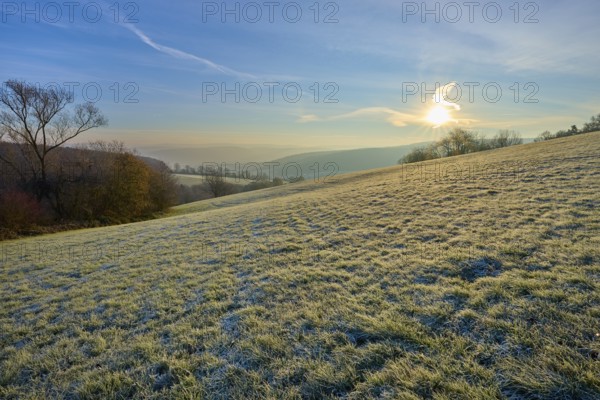 Soft sunlight and frost over a range of hills on a clear morning, Seckmauern, Lützelbach, Maintal, Odenwald, Hesse, Germany