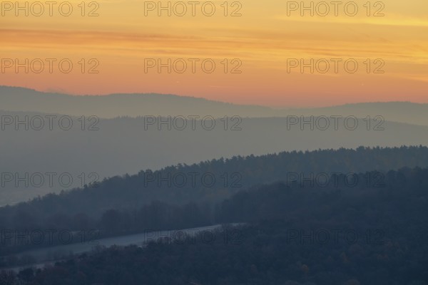 Gentle hills in fog at a warm sunset create a peaceful natural landscape, Seckmauern, Lützelbach, Maintal, Odenwald, Hesse, Germany