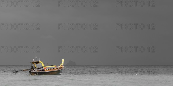 Longtail boat (Thai: Ruea Hang Yao) on the beach, behind it an approaching thunderstorm, Koh Ngai island, Andaman Sea, Satun province, southern Thailand, Thailand