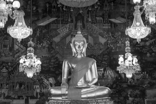 Golden Buddha statue, Phra Buddha Trilokachet surrounded by crystal chandeliers and exquisite wall paintings, interior view of Phra Ubosot or ordination hall, Wat Suthat Thepwararam, Royal Temple, Phra Nakhon, Bangkok, Thailand