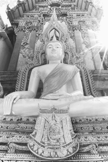 Buddha statue with tunic, Bhumispara mudra, Buddha Gautama at the moment of enlightenment, at the entrance to Wat Sitthawararam, Bangkok, Thailand