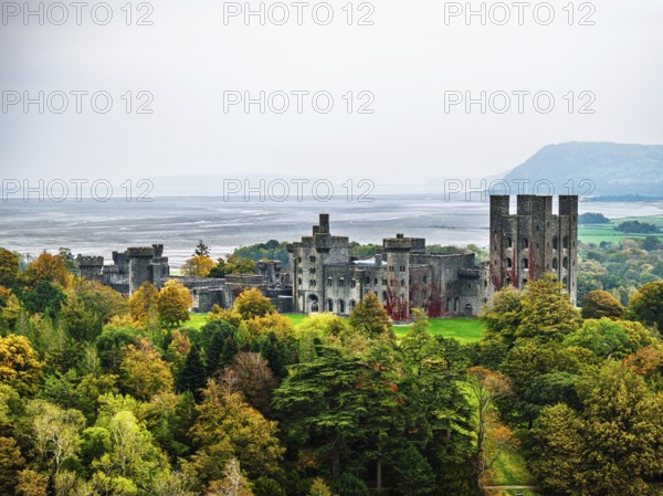 Autumn colours over Penrhyn Castle and Garden from a drone, Llandygai, Bangor, Gwynedd, North Wales, UK
