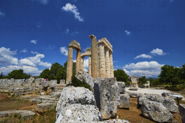 Ancient remains and columns surrounded by large stones under a cloudless sky, Nemea, Ancient Zeus Church, Archaeological Site, Peloponnese, Greece