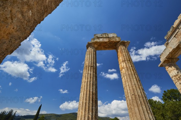 Massive ancient pillars rise against a bright blue sky, Nemea, Ancient Zeus Church, Archaeological Site, Peloponnese, Greece