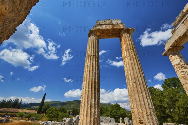 Ancient ruins stand imposing against a clear blue sky with some clouds, Nemea, Ancient Zeus Church, Archaeological Site, Peloponnese, Greece