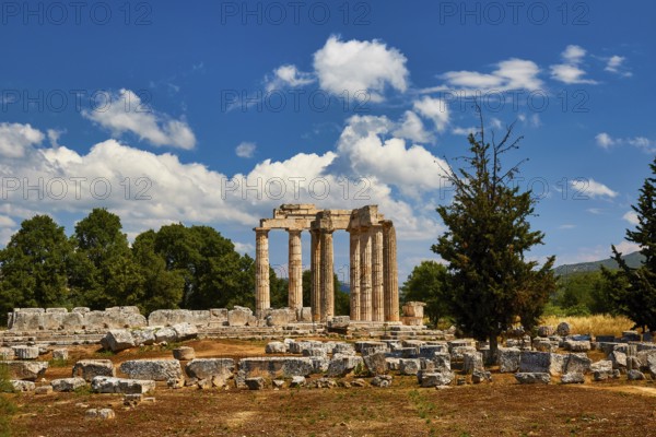 Stone ruins and ancient pillars against a cloudy blue sky, Nemea, Ancient Zeus Church, Archaeological Site, Peloponnese, Greece