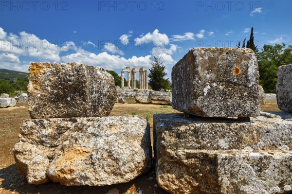 Ancient ruins with large stones against a bright blue sky with clouds, Nemea, Ancient Zeus Church, Archaeological Site, Peloponnese, Greece