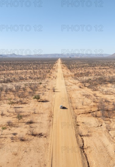 Travel, aerial view, car driving on road through arid landscape, Kunene region, Namibia
