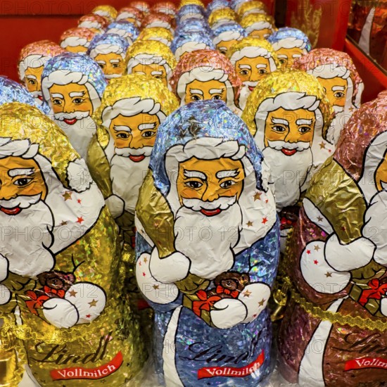 Display on the shelf of chocolate Santa Claus chocolate Santa Claus Santa Claus Santa Claus Santa Claus chocolate Santa Claus chocolate Santa Claus chocolate lice Santa Claus chocolate lice Santa Claus in color red of colored staniol paper made of chocolate arranged like army of Santa Claus, Germany
