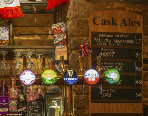 Cask ale menu of different brands inside the Ship pub, Exeter, Devon, England, UK - keg beer taps in foreground