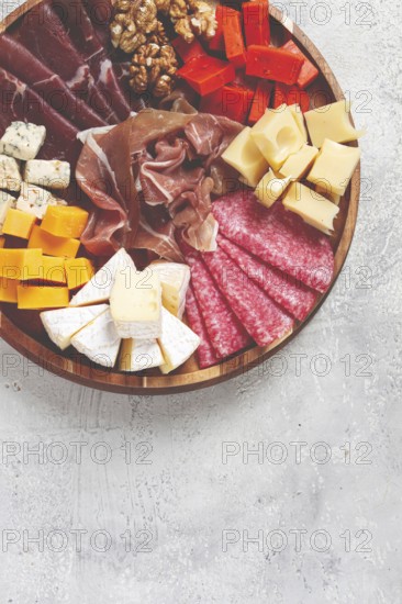 Assortment of cheese meat cuts, on a plate, top view, no people