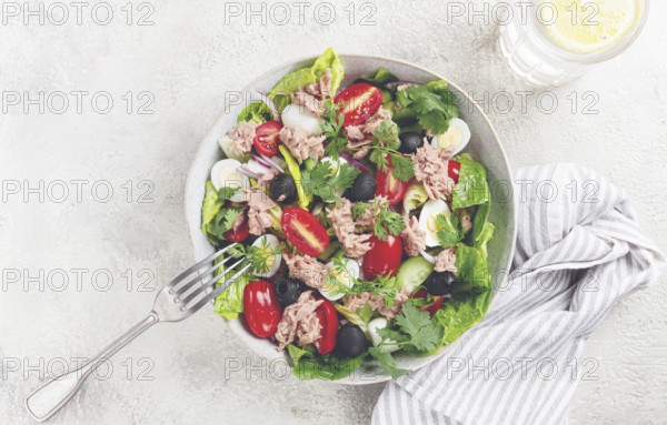 Salad with canned tuna, vegetable salad with quail eggs, lettuce and romaine leaves, red onion, cherry tomatoes, olives, keto food, healthy eating