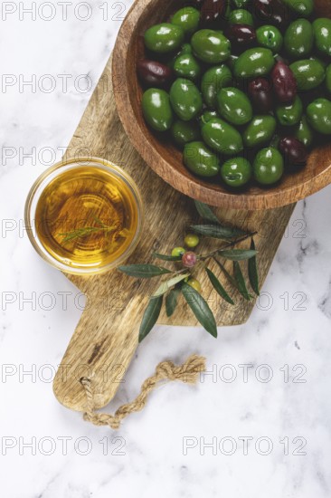 Chalkidiki olives, classic Greek green olives, in a bowl on a cutting board, top view, without people