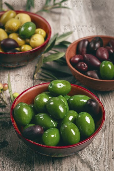 A mixture of olives, varieties of chalkidiki, Verdi giganti and Kalamata, in a bowl, top view, no people