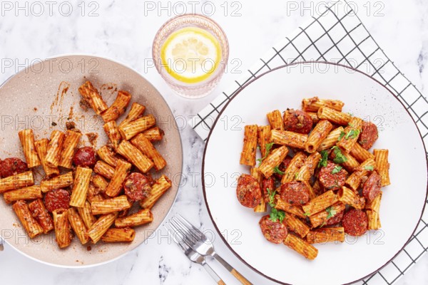 Rigatoni pasta with spicy sausage, and rich tomato sauce served, on a white plate, homemade