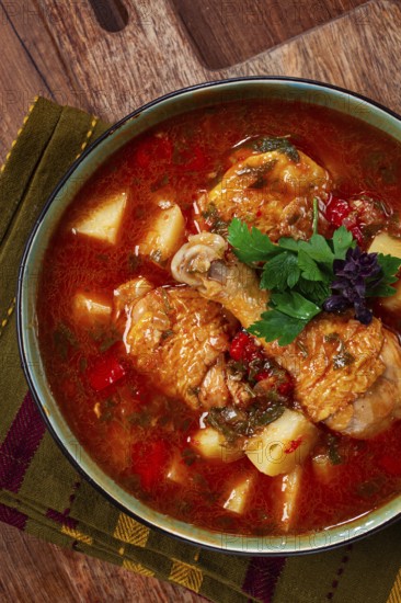 Souzi soup. Georgian dish, meat with oats, tomato sauce and herbs, on a wooden table