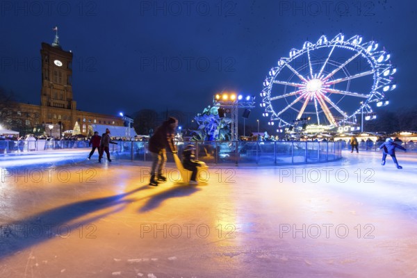 Skaters in front of the Red Town Hall, Neptune Fountain and a Ferris wheel at the Berlin Christmas market on Alexanderplatz, Berlin, 24.11.2025