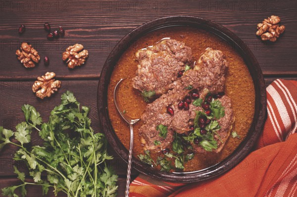 Fesenjan, an Iranian dish, stewed chicken, in walnut-pomegranate sauce, in an earthen pan, homemade, no people