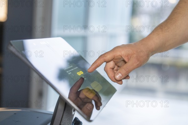 Close-up of a hand interacting with a touchscreen in a modern setting, robotic personality Roboloutions in the jewelry museum, Pforzheim, Germany