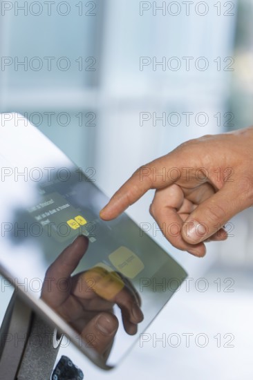 Close-up of a hand touching a touchscreen with reflective display, robotic personality Roboloutions in the jewelry museum, Pforzheim, Germany