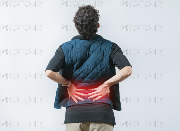 Person with spine problems. Man with pain holding his back. Lumbar problems. Suffering male with pain holding his back isolated