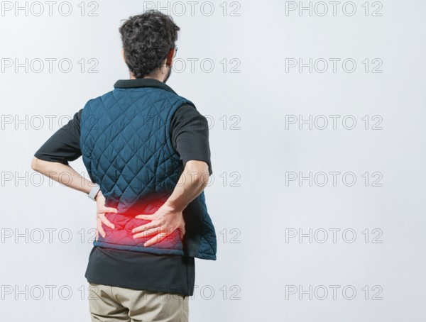 Lumbar problems. Suffering male with pain holding his back isolated. Person with spine problems. Man with pain holding his back