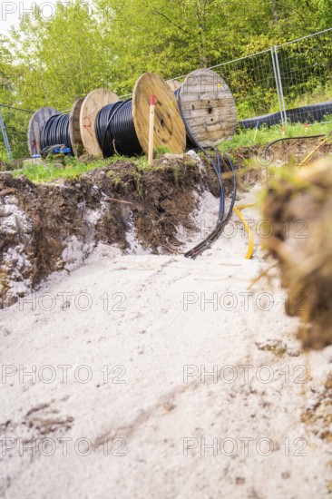 Trench with cable rolls in the foreground and construction work in the background, PV Freifaechenanlage construction, Weil der Stadt, Germany