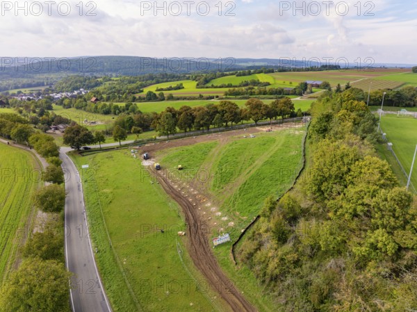 Extensive green landscape with roads and trees under a cloudy sky, Bau PV Freifaechenanlage, Weil der Stadt, Germany