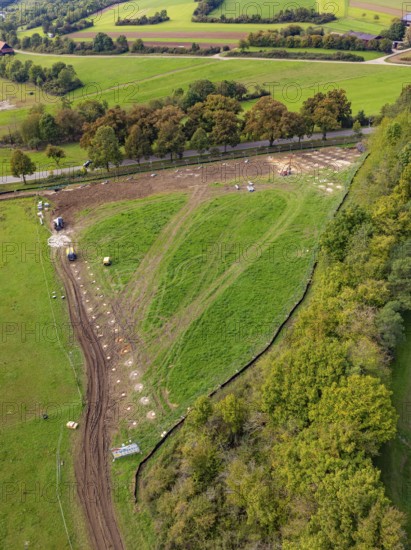 View of hilly landscape with a path surrounded by green fields and trees, construction PV Freifaechenanlage, Weil der Stadt, Germany