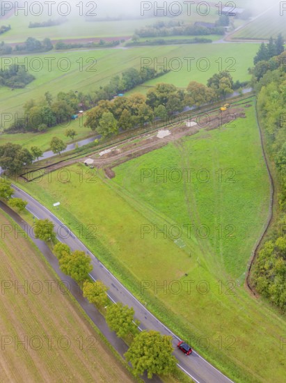 Aerial view of a vast green field with a construction site and road, PV Freifaechenanlage construction, Weil der Stadt, Germany