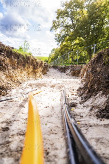 View of a ditch with cables during construction under sunny skies, PV Freifaechenanlage construction, Weil der Stadt, Germany