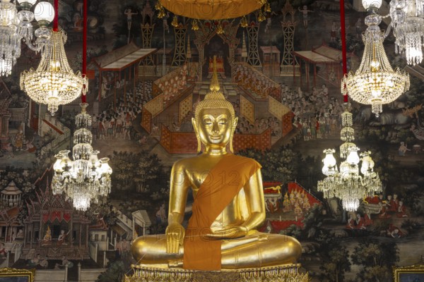 Golden Buddha statue, Phra Buddha Trilokachet surrounded by crystal chandeliers and exquisite wall paintings, interior view of Phra Ubosot or ordination hall, Wat Suthat Thepwararam, Royal Temple, Phra Nakhon, Bangkok, Thailand