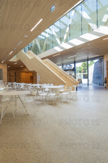 Spacious, modern atrium with wooden paneling and glass roof, furnished with white minimalist furniture, Ruhestein National Park Center, Black Forest, Baiersbronn, Germany