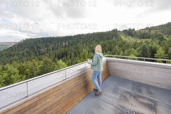 Person looking at the extensive forest landscape from an elevated vantage point, Ruhestein National Park Center, Black Forest, Baiersbronn, Germany
