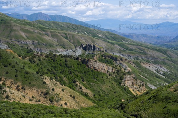 Rocks and green hills stretch under a blue sky, rocky landscape, landscape from the south towards Vardenyats Pass or Selim Pass, Vayots Dzor province, Armenia