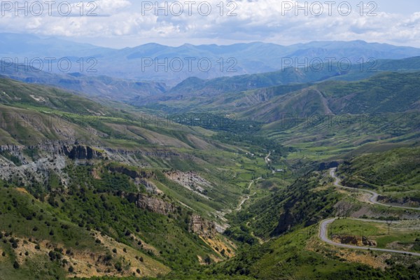 Panoramic view of mountains, green landscape with winding roads, blue sky, landscape from south towards Vardenyats Pass or Selim Pass, Vayots Dzor province, Armenia