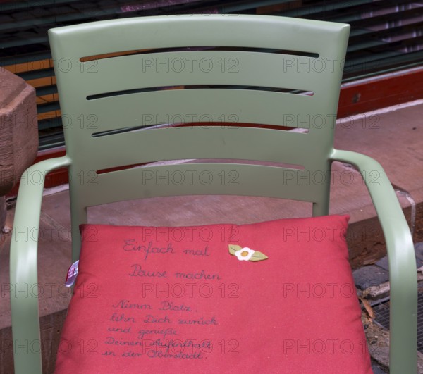 Cushion on chair with city advertising, Oberstadt, Marburg, Hesse, Germany