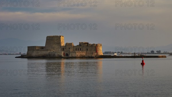 Bourtzi island fortress, old fort on a small island in calm sea with a red buoy in the foreground, Nauplion, Nafplion, Peloponnese, Greece