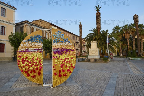 Old town of Nauplion, colorful flower installation on a town square with palm trees and monuments, Nauplion, Nafplion, Peloponnese, Greece