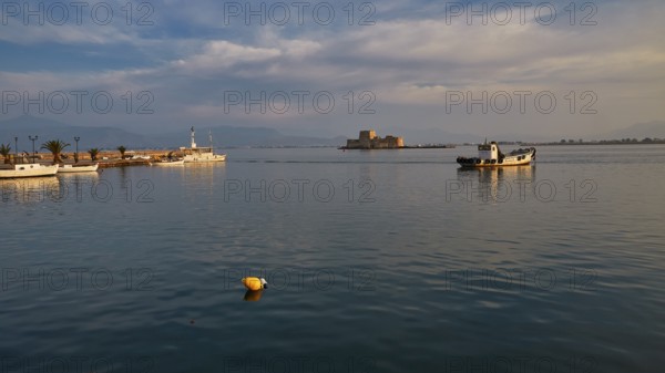 Bourtzi island fortress, port of Nauplion, A quiet harbor with boats and a small fortress under a partly cloudy sky, Nauplion, Nafplion, Peloponnese, Greece