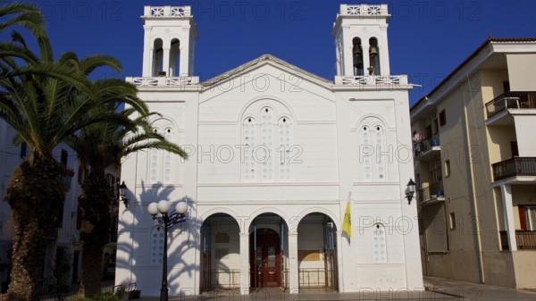 Old town of Nauplion, white church with palm trees in the foreground under clear sky, Nauplion, Nafplion, Peloponnese, Greece