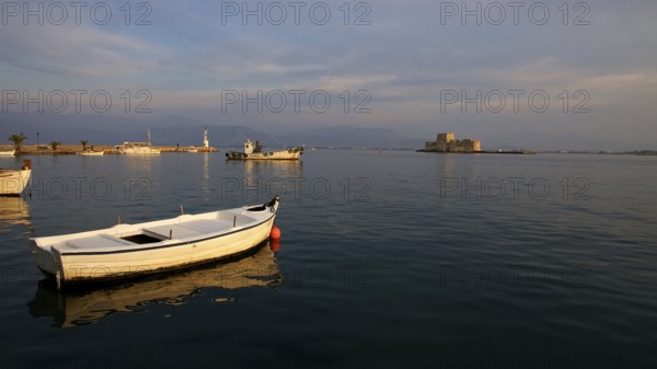 Nauplion harbour, Bourtzi island fortress, white boats on the calm sea at dusk with a fortress in the background, Nauplion, Nafplion, Peloponnese, Greece