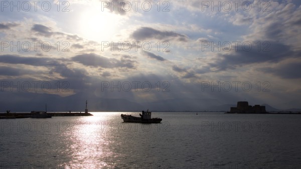 Nauplion harbour, Bourtzi island fortress, atmospheric picture with sunbeams over the water at sunset, Nauplion, Nafplion, Peloponnese, Greece