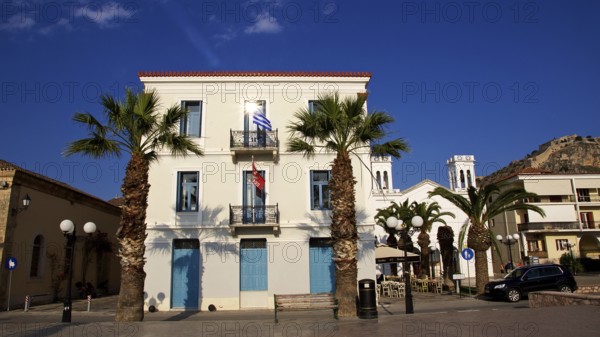 Old town of Nauplion, white building with blue shutters and palm trees in the foreground, Nauplion, Nafplion, Peloponnese, Greece