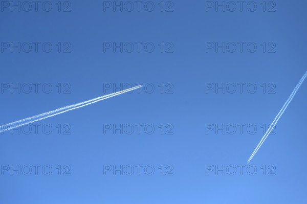 Two airliners with contrails in the blue sky, Bavaria, Germany