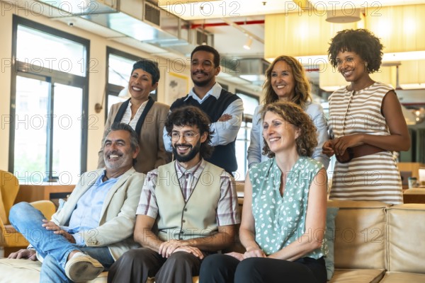 Diverse group of smiling coworkers in a modern coworking office, posing together to convey teamwork, collaboration, positivity and professional success in a relaxed setting