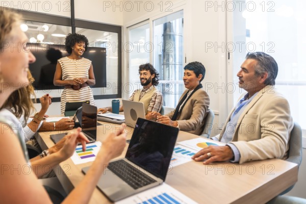 Multiracial team of business colleagues actively collaborating and discussing project strategies while attending a professional meeting in a modern office or coworking space